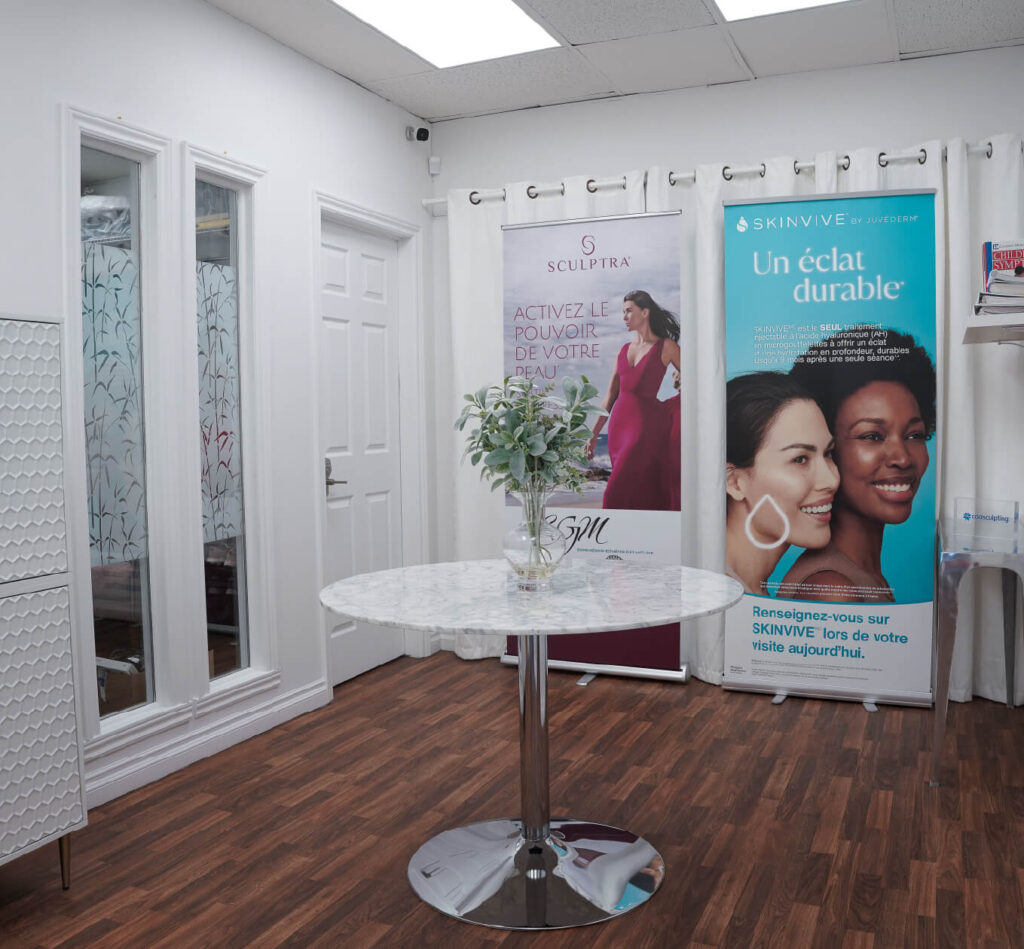 Espace d’accueil avec table ronde et affiches promotionnelles des traitements Sculptra et Skinvive