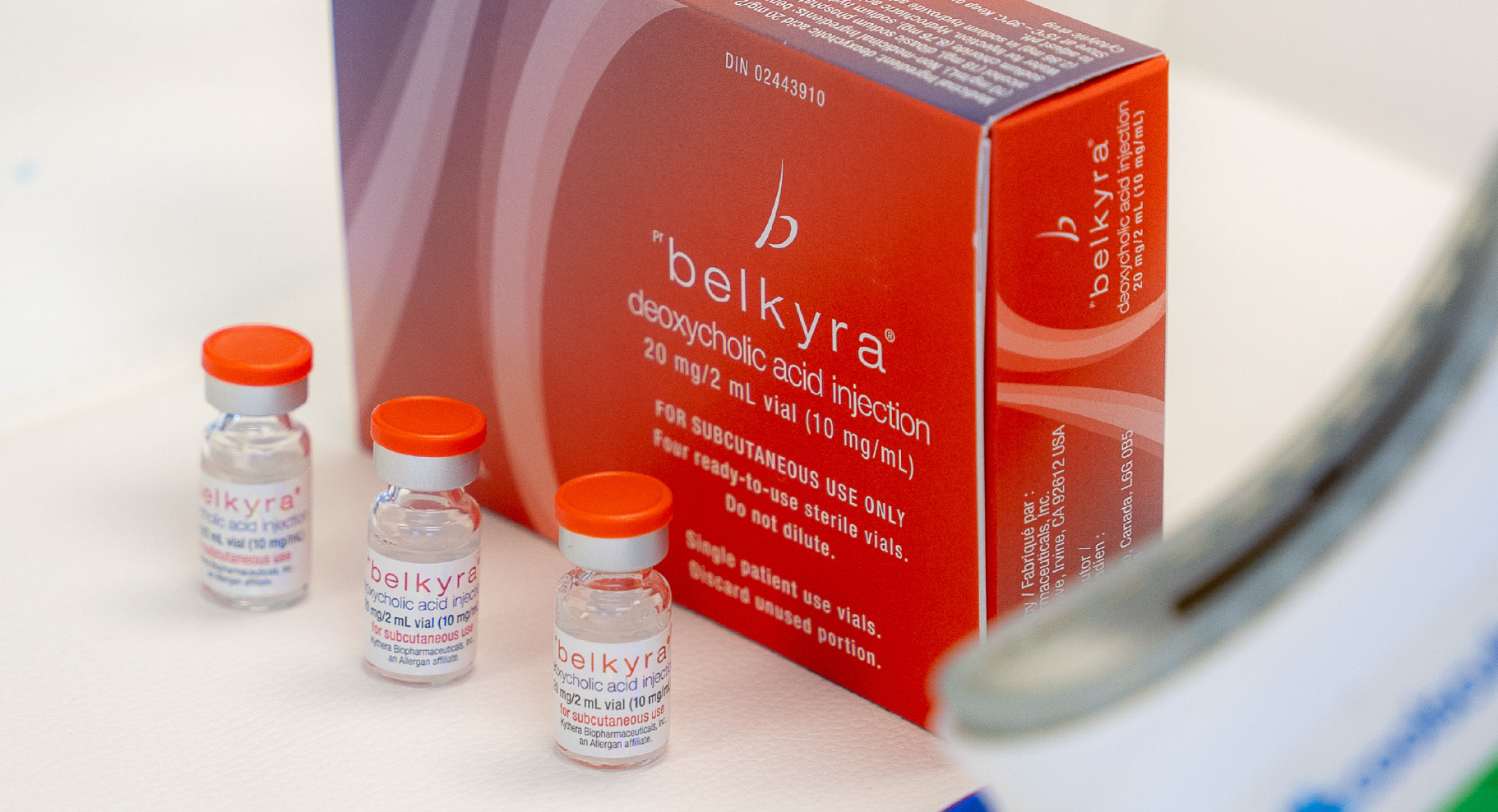 Trois fioles de Belkyra placées devant une boîte rouge du produit