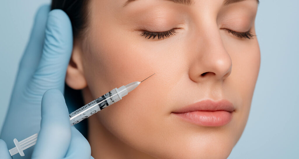 Injection esthétique dans la joue d’une femme pour réduire les rides ou restaurer le volume du visage, traitement à base de neuromodulateur ou d’acide hyaluronique.