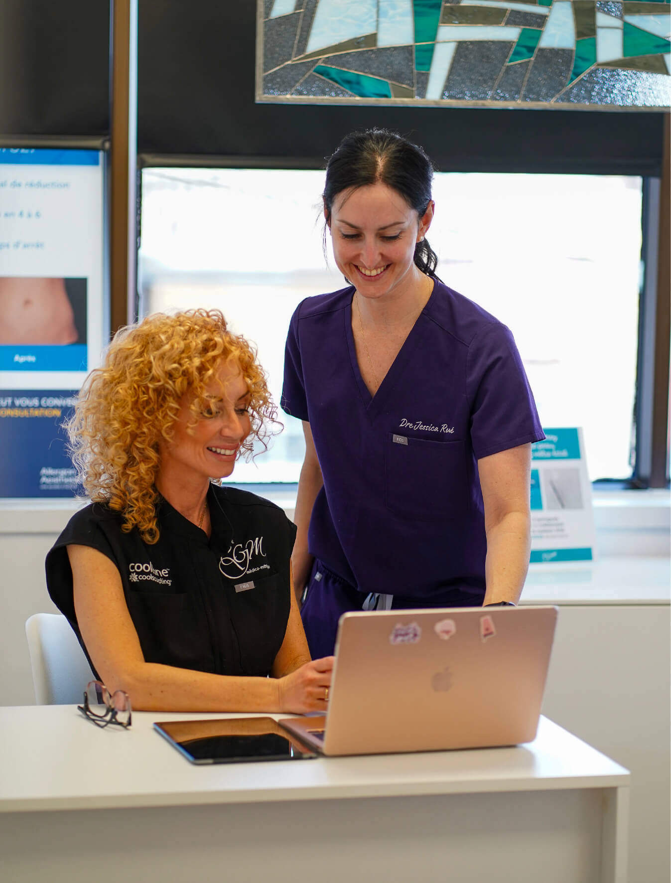 Dr Jessica René et une collègue de la clinique CGM discutent d’un dossier client devant un ordinateur portable, dans un environnement clinique moderne et chaleureux.