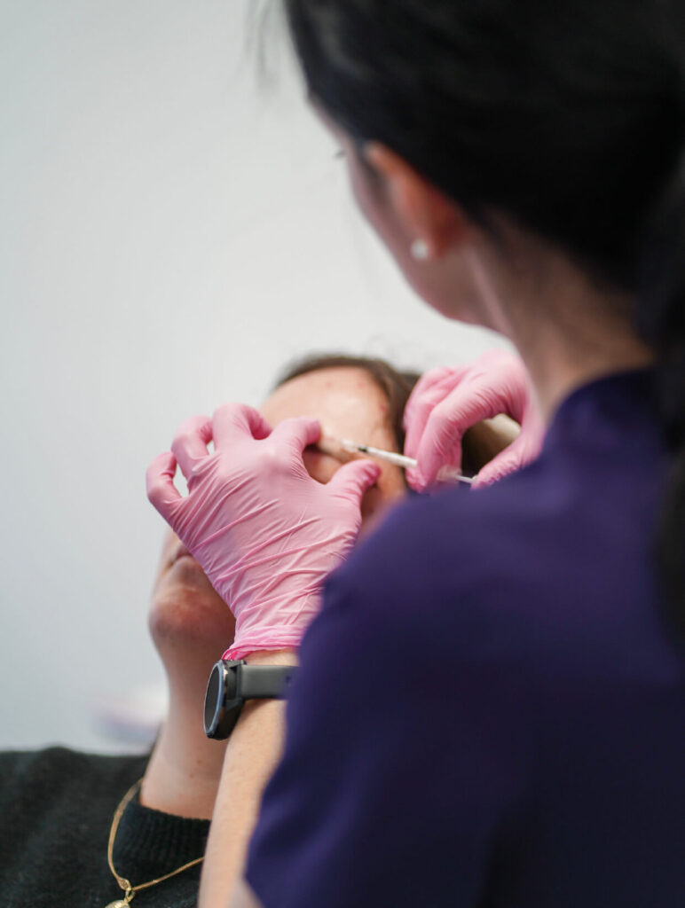 Injection de neuromodulateur dans la zone du front par une professionnelle en clinique médico-esthétique.